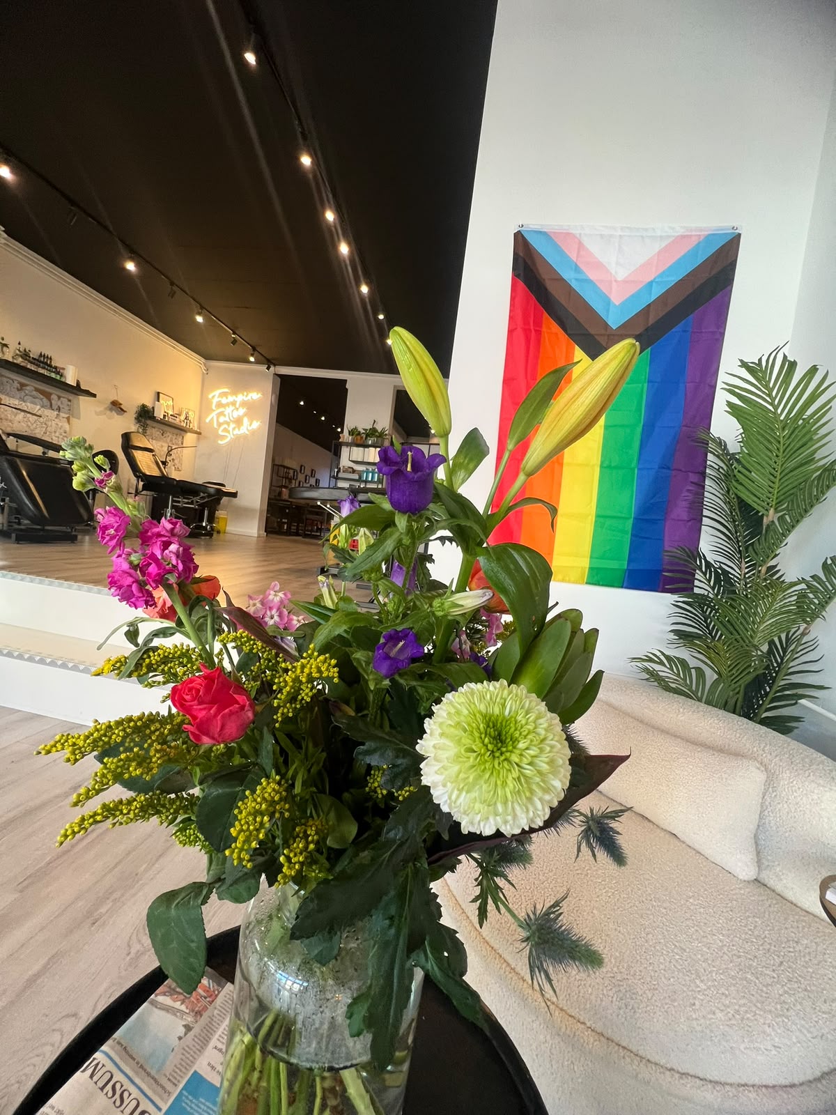 Bloemen en een progress-pride-doek in Fempire Tattoo Studio